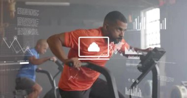 Spor salonunda eliptik bisikletlerle egzersiz yapan farklı adamların veri işleme ve diyagramlarının animasyonu. Spor ve dijital arayüz konsepti dijital olarak oluşturulmuş video.