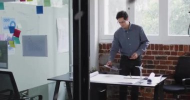 Ofiste tablet kullanan Kafkasyalı işadamının veri işleme sürecinde olduğu bir dünya animasyonu. Küresel finans, iş, bağlantılar, hesaplama ve veri işleme kavramı dijital olarak oluşturulmuş video.