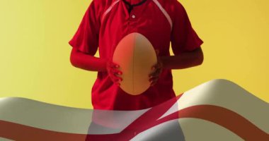 İngiliz bayrağının animasyonu, çift ırklı kadın rugby oyuncusunun topu tutması üzerine. Spor, vatanseverlik ve dijital arayüz konsepti dijital olarak oluşturulmuş video.