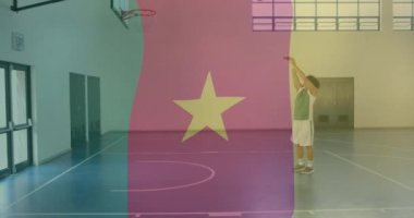 Çift ırklı erkek basketbolcunun spor salonunda top atması üzerine kamerun bayrağı animasyonu. Spor, bayraklar ve dijital arayüz konsepti dijital olarak oluşturulmuş video.