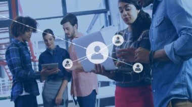 Tablet ve dizüstü bilgisayar kullanan çeşitli meslektaşlar üzerindeki simgelerle bağlantı ağının animasyonu. Küresel iş, bağlantılar, iletişim ve dijital arayüz kavramı dijital olarak oluşturulmuş video.