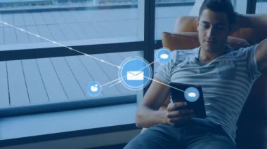 Tablet kullanan beyaz adamın üzerindeki simgelerle bağlantı ağının animasyonu. Küresel iş, bağlantılar, iletişim ve dijital arayüz kavramı dijital olarak oluşturulmuş video.