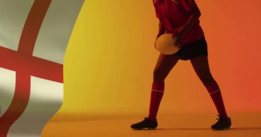 İngiliz bayrağının animasyonu, çift ırklı kadın rugby oyuncusunun topu tutması üzerine. Spor, vatanseverlik ve dijital arayüz konsepti dijital olarak oluşturulmuş video.