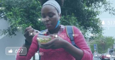 Afro-Amerikan bir kadının öğle yemeği yemesi üzerine medya simgelerinin canlandırılması. Gıda, sosyal medya ve dijital arayüz konsepti dijital olarak oluşturulmuş video.