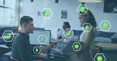 Ekoloji simgelerinin canlandırılması ve çeşitli meslekdaşların ofiste iş görüşmesi üzerine veri işleme. Küresel iş, bilgisayar ve dijital arayüz kavramı dijital olarak oluşturulmuş video.