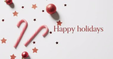 Kırmızı renkli, bastonlu, yıldızlı ve beyaz arkaplanlı mutlu bayramlar mesajları. Noel, gelenek, selamlar ve dijital olarak oluşturulan video kutlaması.