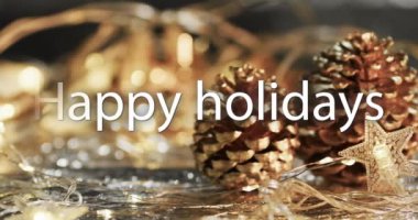 Çam kozalakları ve Noel süslemeleri üzerine beyaz renkli mutlu bayramlar mesajı. Noel, gelenek, selamlar ve dijital olarak oluşturulan video kutlaması.