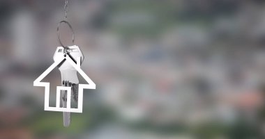 Bulanık şehir manzarasının üzerinde anahtarları olan ev şeklinde anahtarlık. Emlak, şehir, yaşam tarzı, mülk, güvenlik, ev