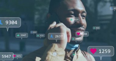 Medya ikonlarının Afro-Amerikan bir adamın akıllı telefondan konuşması üzerine animasyonu. Teknoloji, sosyal medya ve dijital arayüz konsepti dijital olarak oluşturulmuş video.