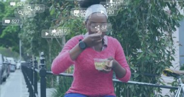 Afro-Amerikan bir kadının şehirde öğle yemeği yemesi üzerine medya ikonlarının canlandırılması. Sosyal medya ve dijital arayüz konsepti dijital olarak oluşturulmuş video.