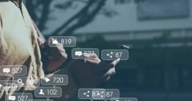 Akıllı telefon kullanan Afro-Amerikan bir adam üzerinde ikon ve veri işleme animasyonları. Dijital olarak oluşturulmuş küresel sosyal medya, bağlantılar, hesaplama ve veri işleme kavramı.