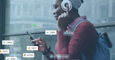 Akıllı telefon kullanan Afro-Amerikan kadın üzerinde ikon ve veri işleme animasyonları. Dijital olarak oluşturulmuş küresel sosyal medya, bağlantılar, hesaplama ve veri işleme kavramı.