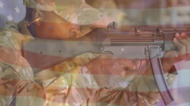Amerikan bayrağının animasyonu tüfekle ateş eden melez erkek askerin üzerinde. Askeri, vatanseverlik ve dijital arayüz konsepti dijital olarak oluşturulmuş video.