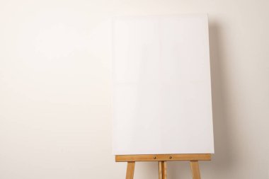 Boş beyaz bir tuval ahşap bir sehpada, kopya alanı ile sergilenir. Sanatçılar ve sunucular için ideal olan tuval, yaratıcılık veya sergilenen çalışmalar için bir başlangıç noktası görevi görüyor..