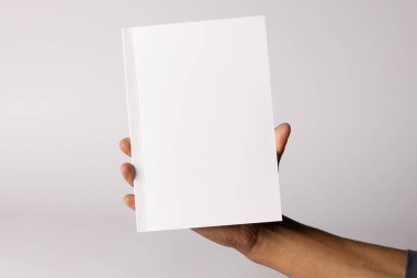 Kopya alanı olan boş bir kitap tutan melez bir adam. Açık ve minimalist bir şekilde kapak tasarımı veya markalaşması için ideal.