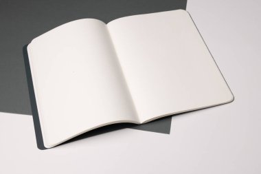 Boş bir defter, fotokopi alanı olan bir masanın üzerinde duruyor. Notları veya yaratıcı fikirleri göstermek için idealdir, defter kişiselleştirmeyi davet eder.