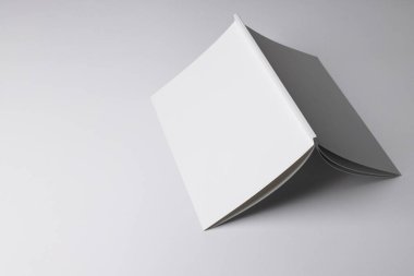 Temiz bir yüzeyde, kopyalama alanı olan boş beyaz bir kitap aç. Minimalist bir ortamda metin, grafik veya eğitim içeriğini göstermek için ideal.