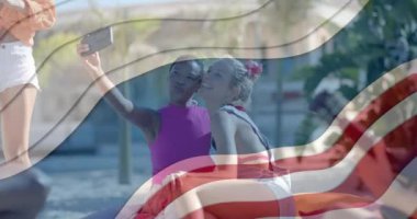 Neşeli kadın arkadaşlarının güneşli sahilde selfie çekmesi üzerine Amerikan bayrak unsurlarının animasyonu. İletişim, Amerika, yaz, arkadaşlık, eğlence ve tatiller, dijital olarak oluşturulmuş video.