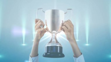 Elinde kupa vardı. Kutlama için ellerini kaldırdı. Parlayan mavi ışıklar. Zafer, başarı, başarı, kazanma, şampiyon, ödül