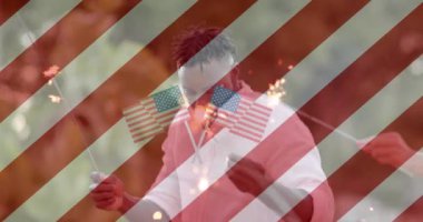 Amerikan bayrakları ve çizgilerinin animasyonu dışarıda maytaplarla dans eden mutlu arkadaşlar üzerinde. Kutlama, Amerika, yaz, vatanseverlik, eğlence, boş zaman ve tatiller, dijital olarak üretilen video.