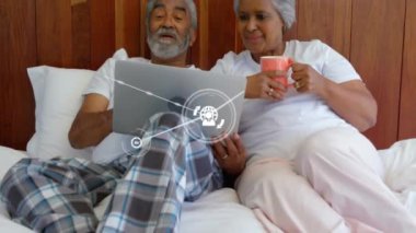 Yatakta dizüstü bilgisayar kullanarak üst düzey melez çiftlerle olan bağlantıların animasyonu. Dijital olarak oluşturulmuş küresel bağlantılar, yaşam tarzı, iletişim ve dijital arayüz kavramı.