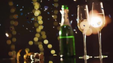 Şampanya bardaklarının ve şişelerin üzerine düşen konfeti animasyonu. Noel, şenlik, kutlama ve gelenek konsepti dijital olarak oluşturuldu.