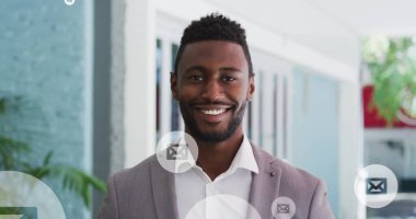 Ofiste dikilen gülümseyen Afro-Amerikan adam üzerinde daireler çizen bir zarf simgesi. Dijital bileşik, çoklu pozlama, soyut, yakın çekim, mesaj ve iş konsepti.