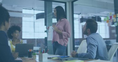 Muhtelif arkadaş grupları ofiste tartışıyor, ellerinde iş evrakları var. Pembe gömlek giyen Afro-Amerikalı kadın, kıvırcık saçlı melez kadın, sakallı beyaz adam.
