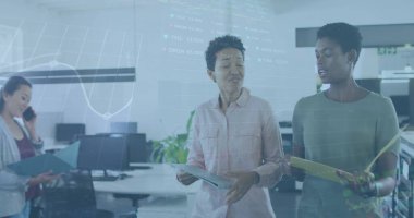 Ofiste yürürken iki farklı kadının tartıştığı borsa veri işleme görüntüsü. Küresel ekonomi ve iş teknolojisi kavramı