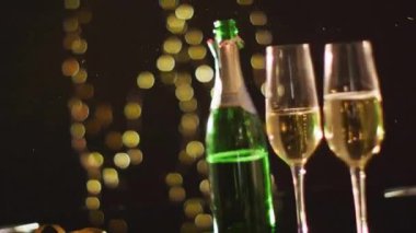 Bardaklar ve bir şişe şampanyayla konfeti animasyonu. Yeni yıl geleneği ve dijital olarak üretilen video konsepti.