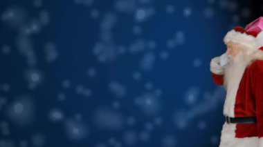 Noel Baba, düşen kar animasyonunun üzerinde hediye kutusuyla kırmızı çuval taşıyor. Noel, tatil, şenlik, kar, kış, kutlama