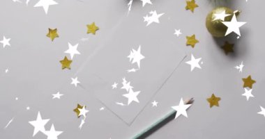 Beyaz arka planda fotokopi alanı olan noel süslerinin üzerine düşen yıldızların animasyonu. Noel, şenlik, kutlama ve gelenek konsepti dijital olarak oluşturuldu.