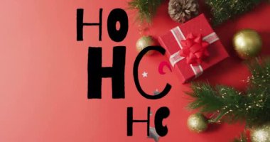 Kırmızı arka plandaki noel süslemeleri üzerine ho ho ho metninin animasyonu. Noel, gelenek ve kutlama konsepti dijital olarak oluşturuldu.