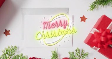 Beyaz arka planda noel süsleri üzerine mutlu noel mesajlarının animasyonu. Noel, şenlik, kutlama ve gelenek konsepti dijital olarak oluşturuldu.