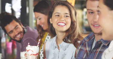 Bir grup arkadaş birlikte eğleniyor, içki içiyorlar. Kıvırcık saçlı melez erkek, kısa saçlı beyaz erkek ve uzun saçlı beyaz kadın, hepsi genç, gülümsüyor.