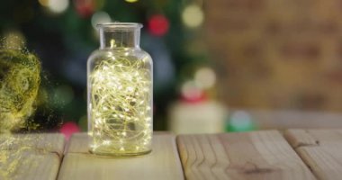 Kavanozun üzerinde parlayan sarı parçacıklar ve ahşap yüzeyde ışıklar. Parlak efekt, aydınlanma, dekorasyon, tuhaf, ruhani, büyüleyici.