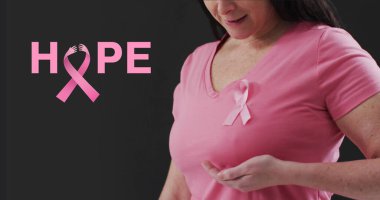 Image of hope text over caucasian woman with pink ribbon on black background. Breast cancer awareness concept, digitally generated image. clipart