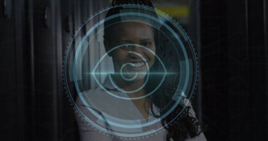Sunucu odasında gülümseyen Afro-Amerikan kadın mühendis üzerindeki göz tarayıcısı görüntüsü. Siber güvenlik ve iş veri depolama teknolojisi kavramı
