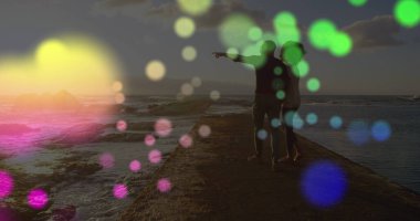 Afrika kökenli Amerikalı bir çiftin deniz kenarındaki kayalıklarda yürüdüğü renkli ışık lekeleri. Aşk ve ilişki kavramı