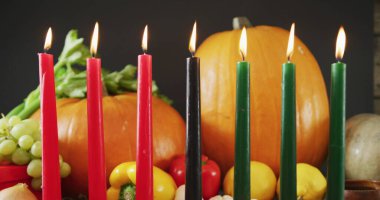 Kwanzaa mumları ve balkabaklarının üzerindeki kırmızı kalplerin resmi. Kwanzaa şenliği, kutlama ve gelenek konsepti, dijital olarak oluşturulmuş görüntü.