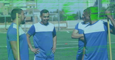 Futbol sahasında gülen bir grup çift ırklı sporcu. Hepsi mavi ve beyaz üniformalar giyiyor, dostluk ve takım çalışması gösteriyorlar.