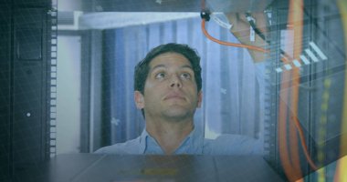 Beyaz erkek sunucu kablolarını kontrol ediyor, odaklanmış görünüyor. Mavi gömlekli, kısa kahverengi saçlı ve açık tenli.