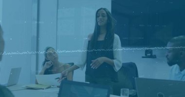 Muhtelif arkadaş grupları ofiste tartışıyor, bir tablet tutuyor. Uzun siyah saçlı melez kadın, çörekli Asyalı kadın, sakallı Afrikalı Amerikalı adam.