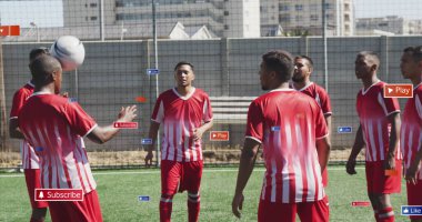 Kırmızı futbol forması giyen bir grup arkadaş sahada antrenman yapıyor. Çeşitli ten renkleri, kısa saçları vardır ve genç yetişkinlerdir.