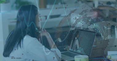 Çift ırklı meslektaşım oturuyor, bilgisayar ekranına bakıyor ve düşünüyor. Uzun siyah saçları var, günlük kıyafetler giyiyor, ofis ortamında.