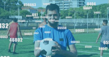 Bir grup çift ırklı sporcu futbol sahasında antrenman yapıyor. Hepsinin kısa saçı var, spor kıyafetler giyiyorlar ve bir tanesi futbol topu tutuyor.