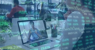 Orta yaşlı Asyalı işadamı dizüstü bilgisayardaki borsa eğilimlerini analiz ediyor. Takım elbiseli, kısa siyah saçlı ve odaklanmış bir ifadesi var.