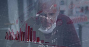 Orta yaşlı bir Kafkasyalı şef restoran sahibi verileri inceliyor, gri saçlı, odaklanmış gözleri var ve kırmızı kazak giyiyor.