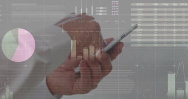 Asyalı yaşlı bir erkek şeffaf ekranda finansal verileri analiz ediyor. Resmi bir gömlek giyiyor, çizelgelere bir stil ile bakıyor, işine odaklanıyor.