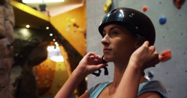 4 k bouldering salonunda yapay duvar tırmanışı önce bir kask giyen kadın